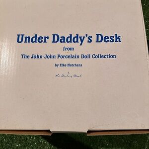 Under daddy‘s desk, the John John porcelain doll collection by Elke Hutchens